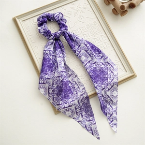 Detail of periwinkle blue satin scrunchie with long ribbon and floral printed patterns