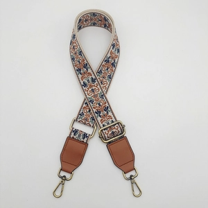 Detail of bohemian canvas strap with vintage floral pattern and bronze metal hooks