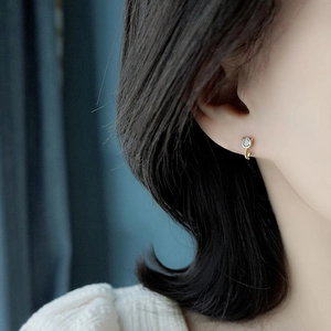 Macro detail of tulip flower stud earring with gold finish and sparkling crystal stone