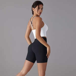 Detail view of white cross-back sports bra and high-waist black fitness yoga shorts