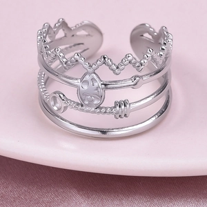 Macro detail of silver adjustable stack ring featuring crown and skull design elements