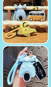 Detail showing cartoon leather transport keychains with woven lanyards on a wooden stand