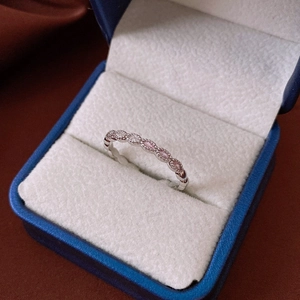 Detailed close-up of zircon ring with pink and white marquise stones on blue box
