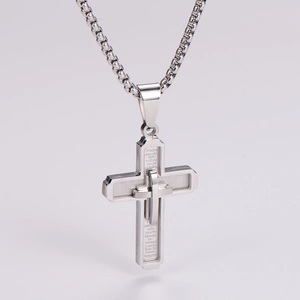 Macro detail of silver layered cross pendant with Spanish Lord's Prayer engraving