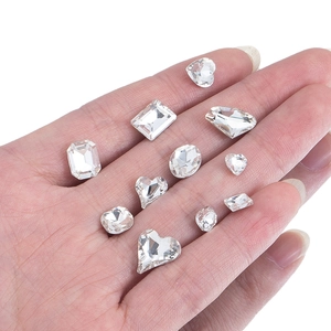 Sparkling clear crystal nail art rhinestones in heart and drop shapes on a hand