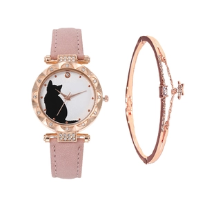 Close-up of rose gold cat motif watch with pink strap and matching star charm bracelet