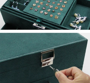 Detail view of deep green velvet jewelry box with key opening the silver metal lock