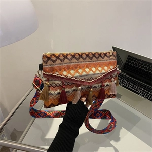 Detail of ethnic crossbody bag with fringe tassels and colorful woven geometric strap