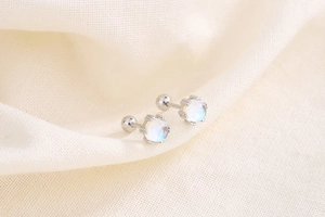 Macro shot of S925 sterling silver moonstone earrings with screw-back closure on fabric