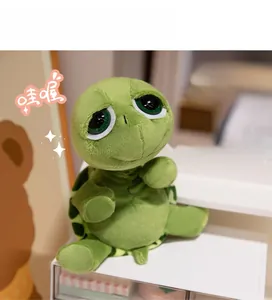 Dettaglio di un peluche a forma di tartaruga con grandi occhi verdi espressivi