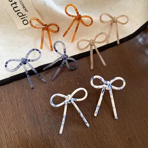 Boucles d'oreilles nœuds en acétate aux motifs ambre et marbre style minimaliste
