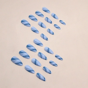 Blue marble almond press-on nails with elegant wavy lines and a glossy finish