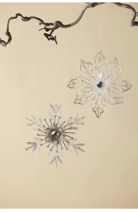 Macro shot of clear acrylic snowflakes with silver glitter edges and grey gemstone centers