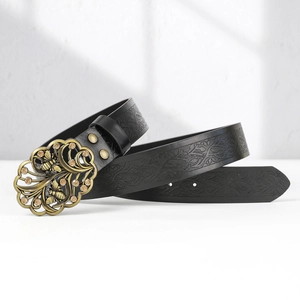 Detail of vintage bronze bee floral buckle and embossed vine texture on black leather belt