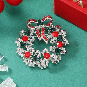 Detail of Christmas wreath brooch with red and green rhinestones on silver alloy