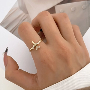 Golden airplane open ring with shimmering crystal wing details on female hand