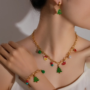 Detail of gold Christmas jewelry set featuring enamel Santa, reindeer and tree pendants