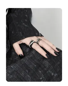 Detail of S925 silver rings with dark lava texture and gold accents on a model