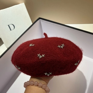 Close-up of red lamb velvet beret with sparkling star rhinestone decorations