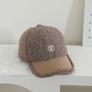 Dettaglio cappello baseball in pile teddy marrone con visiera in velluto e logo R ricamato