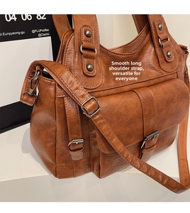 Close-up of brown PU leather tote bag showing multi-pocket structure and metal buckles