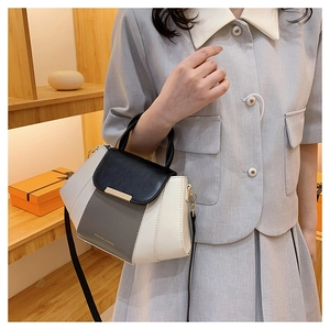 Detail of color-block tote bag featuring top handle and detachable shoulder strap in daily use