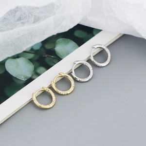 Detailed view of gold and silver S925 sterling silver hoop earrings with pavé crystals