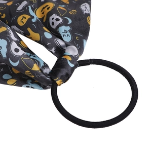 Detail of Halloween hair scrunchie with skull ghost and pumpkin printed bow ribbon