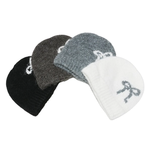 Detail of four knit hats in black, grey, and white with elegant bow jacquard patterns
