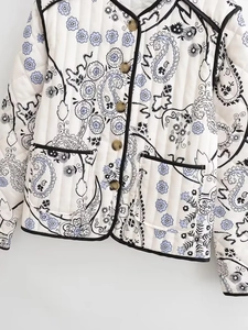 Detail of quilted cotton jacket with purple floral and paisley print with brown buttons