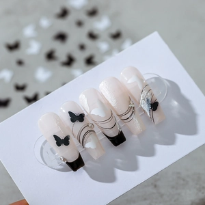 Elegant butterfly nail stickers in milky white with black patterns and rhinestones