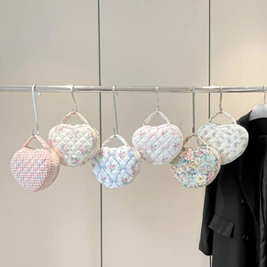 Detailed row of quilted cotton heart-shaped makeup bags with floral and plaid patterns