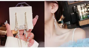 Detailed view of long gold tassel earrings with white pearls and S925 silver needles