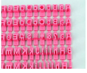 Macro detail of pink plastic alphabet and number stamps for DIY cookie baking molds