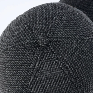 Detail of dark grey knitted winter hat showing high-quality stitching and textured fabric