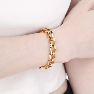 Close-up of thick 18K gold-plated Cuban chain link bracelet worn on a wrist