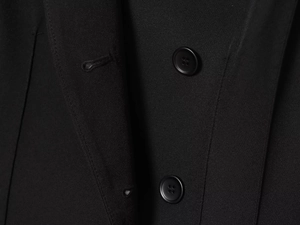 Gros plan détaillé du tissu sergé noir de haute qualité et des boutons d'un blazer cintré