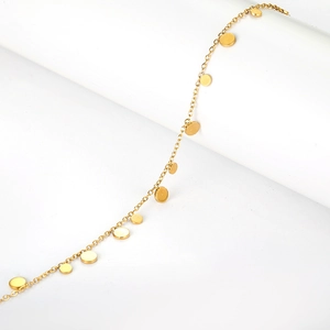 Minimalist gold plated stainless steel bracelet with flat circular charms on white background