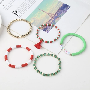 Detailed view of Christmas bead bracelets with holly letters, tassels and charms