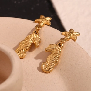 Macro shot of 18K gold plated stainless steel starfish and seahorse earrings