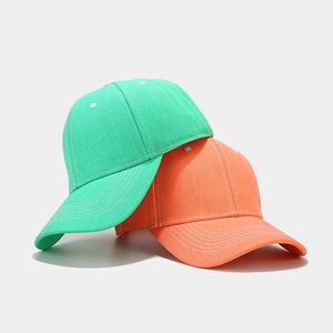 Green and orange cotton baseball caps with visible white stitching on a white background
