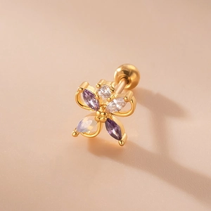 Macro shot of gold flower cartilage stud with purple zircons and screw ball back