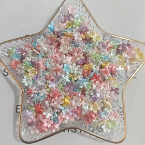 Macro shot of colorful mini five-petal resin flower beads with pearlescent finish