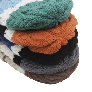 Detail view of chunky cable knit beanies in various colors like green and orange