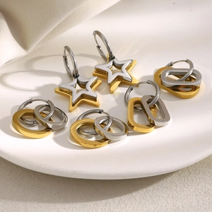 Detail of star-shaped and geometric hoop earrings in gold and silver finish
