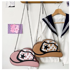 Detail of cowboy hat chain bags in pink and brown cow print with star accents