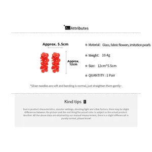 Detail view of red fabric flower earrings with faux pearls and size specifications
