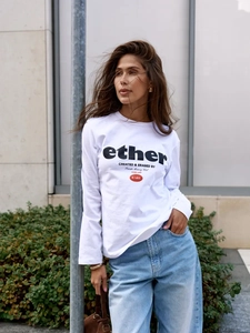 Street style φωτογραφία ενός λευκού βαμβακερού μακρυμάνικου t-shirt με vintage γράμματα