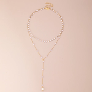 Elegant gold double layer Y-shaped pearl necklace with long pendant on pink background
