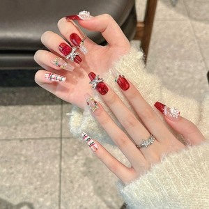 Handmade red Christmas press-on nails featuring 3D Santa and glitter long coffin shapes